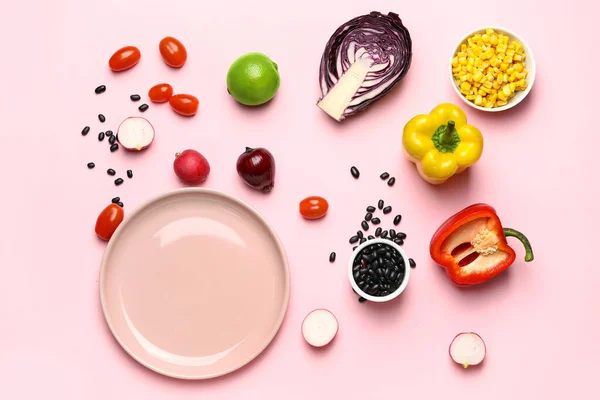 Composition with ingredients for Mexican vegetable salad on pink background