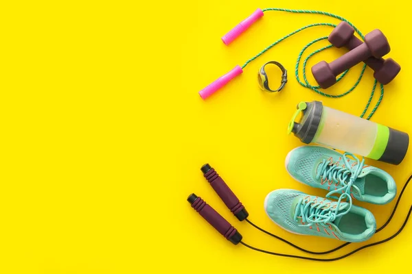 黄色の背景にスポーツ用品 水と靴のボトル — ストック写真