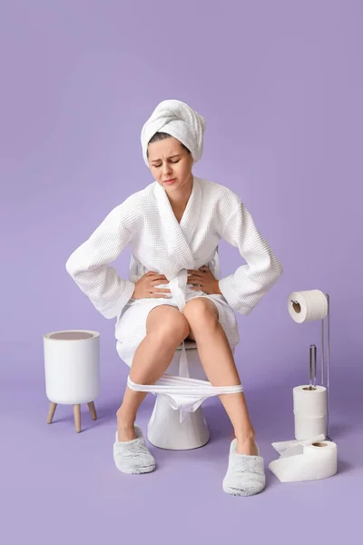 Young Woman Suffering Diarrhea While Sitting Toilet Bowl Color Background — Stock Photo, Image