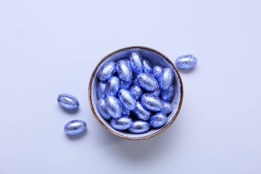 Renkli arkaplanda bir kase çikolata Paskalya yumurtası