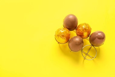 Sarı arka planda çikolatalı Paskalya yumurtası.