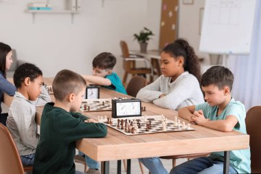 Kulüpte turnuvada satranç oynayan küçük çocuklar.