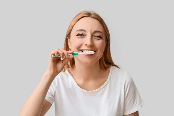 Beautiful Mature Woman Brushing Teeth Light Background — Stock Photo, Image