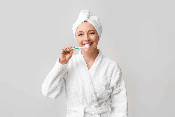 Beautiful Mature Woman Bathrobe Brushing Teeth Light Background — Stock Photo, Image