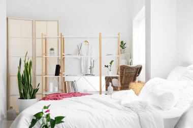 Kitap rafları ve küveti olan aydınlık yatak odasının içi.