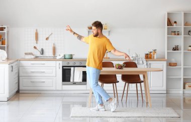 Evde dans eden havalı genç adam.