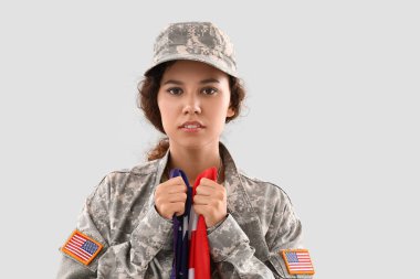 Beyaz arka planda Amerikan bayrağı olan Afro-Amerikalı kadın asker.