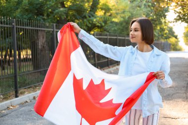 Kanada bayrağı taşıyan güzel genç bir kadın.