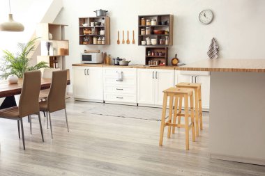 Beyaz tezgahları ve yiyecekleri olan, aydınlık, modern bir mutfak.