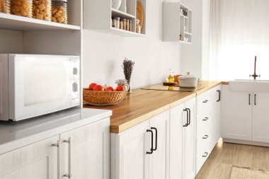 Beyaz tezgah ve sepetli, aydınlık, modern mutfağın içi.