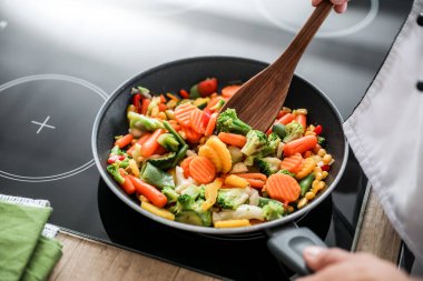 Mutfakta spatula kızartan erkek aşçı, yakın plan.