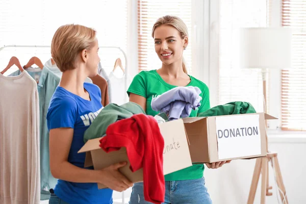 Ehrenamtliche Helferinnen Halten Kartons Mit Kleidungsstücken Für Die Spende Raum — Stockfoto