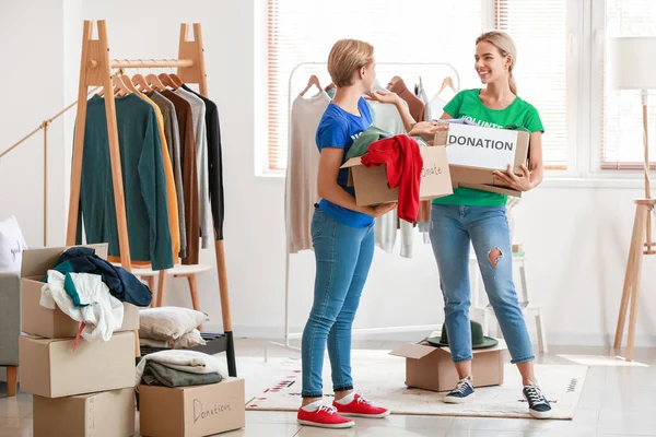 Female Volunteers Holding Boxes Clothes Donation Room — Stock Photo, Image