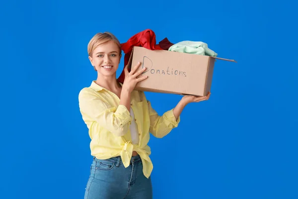 Young Woman Holding Box Clothes Donation Blue Background — Stock Photo, Image