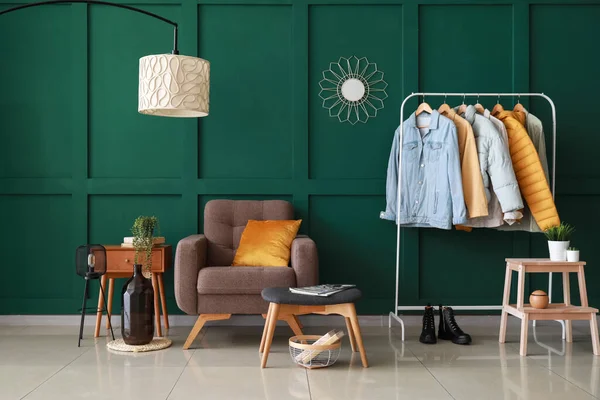 带有现代家具的时髦房间和靠近绿色墙壁的夹克衫的室内 — 图库照片