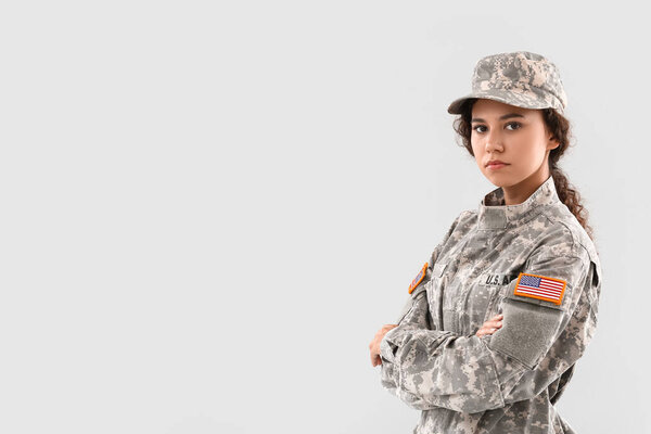 African-American female soldier on light background