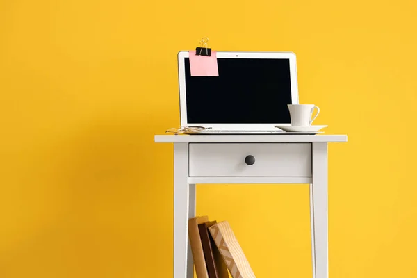 Laptop Kleine Witte Tafel Met Boeken Bij Gele Muur — Stockfoto