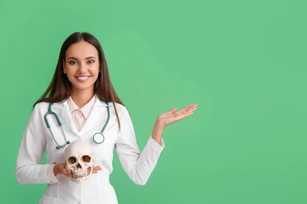 Kvinna Läkare Med Mänsklig Skalle Visar Något Färg Bakgrund — Stockfoto