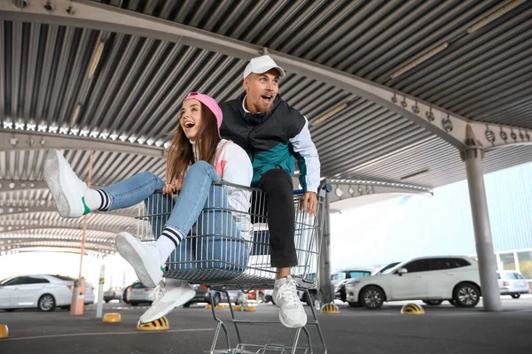 Glückliches Junges Paar Sitzt Einkaufswagen Auf Parkplatz — Stockfoto