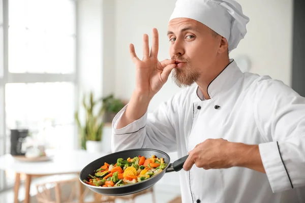 キッチンでおいしい野菜とフライパンを保持男性シェフ — ストック写真