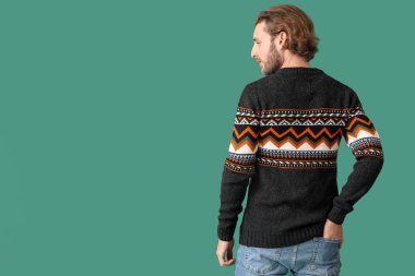 Renkli süveter giyen yakışıklı bir genç.