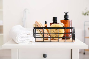 Farklı banyo malzemeleri ve havluyla dolu bir sepet.