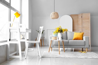 Masada mimoza çiçekleri, oturma odasının iç kısmında da kanepe olan vazo.