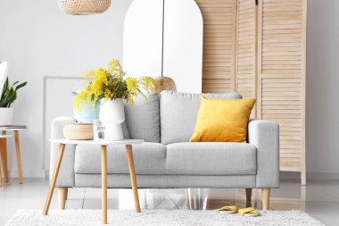 Masada mimoza çiçekleri, oturma odasının iç kısmında da kanepe olan vazo.