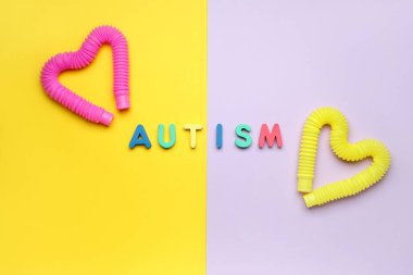 Renk arkaplanında Pop Tüpleri olan Kelime AUTISM