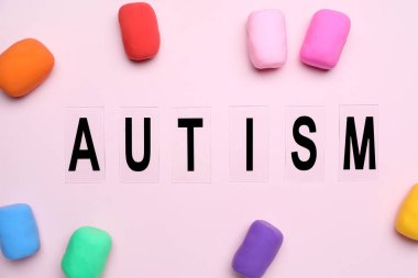 Pembe arka planda plastiksi olan kelime AUTISM