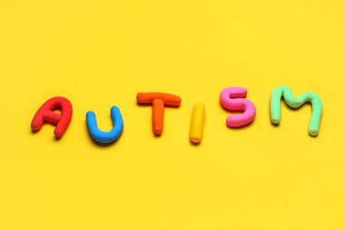 Sarı arkaplanda renkli sözcük AUTISM