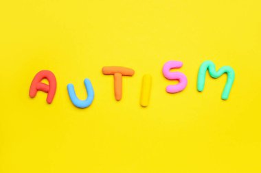 Sarı arkaplanda renkli sözcük AUTISM