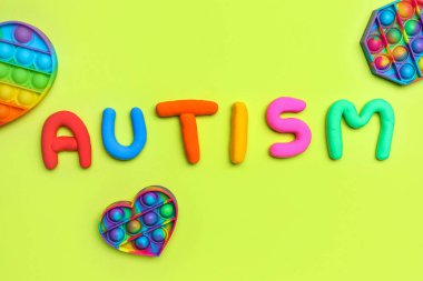 Kelime AUTISM ile pop it 's Fredget oyuncakları yeşil arka planda