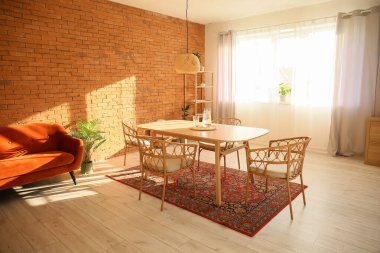 Masası ve eski halısı olan modern yemek odası.