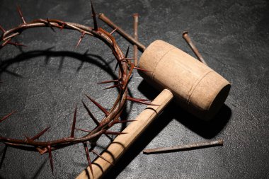 Dikenli taç, çekiç ve siyah arka planda tırnaklar.