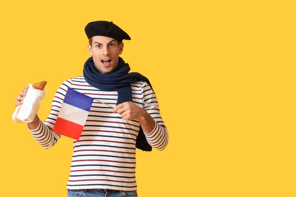 Joven Sorprendido Con Bandera Francia Cruasanes Sobre Fondo Amarillo —  Fotos de Stock