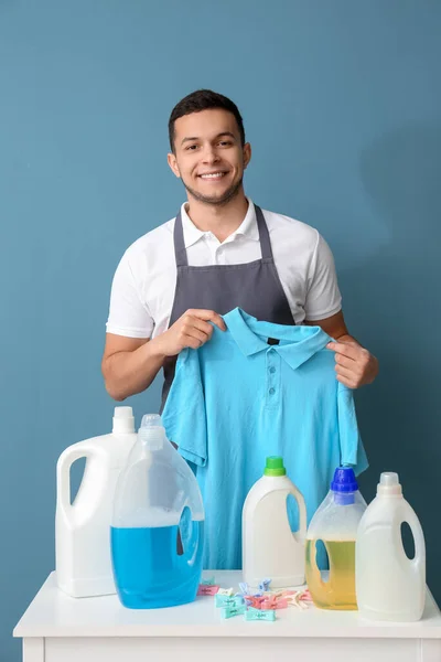 Νεαρός Άνδρας Shirt Τραπέζι Μανταλάκια Και Μπουκάλια Απορρυπαντικού Μπλε Φόντο — Φωτογραφία Αρχείου