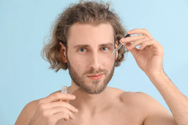 Jongeman Met Serum Voor Huidverzorging Kleur Achtergrond — Stockfoto