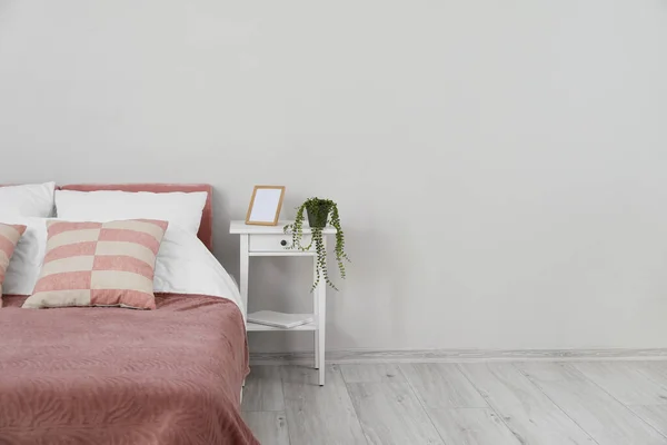 Comfortabel Bed Nachtkastje Met Houseplant Blanco Frame Bij Lichte Wand — Stockfoto