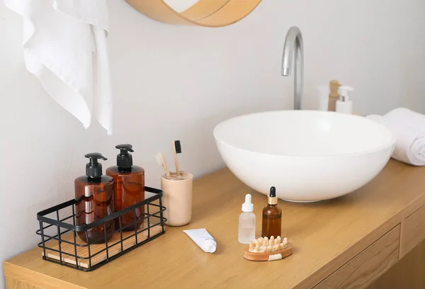 バスルームの白い壁の近くのテーブルの上の歯ブラシ マッサージボディブラシと化粧品 — ストック写真