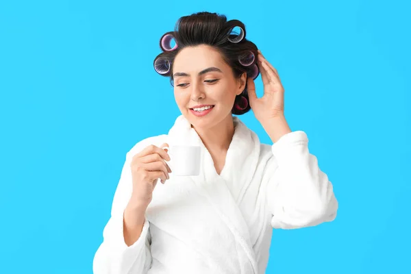 Beautiful Young Woman Bathrobe Hair Curlers Drinking Coffee Blue Background — Stock Photo, Image