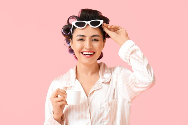 美しいです若いです女性でパジャマ ヘアカラー サングラスを飲みながらコーヒーピンクの背景 — ストック写真