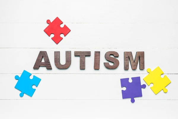Sana Autism Palapelin Palaset Valkoisella Puupohjalla — kuvapankkivalokuva