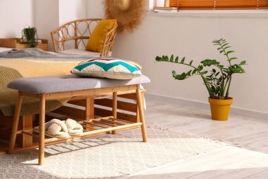 Yatak odasında yastıklı ve terlikli modern bank