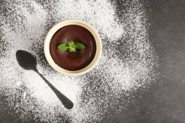 Koyu arkaplanda lezzetli lav keki olan ramekin.