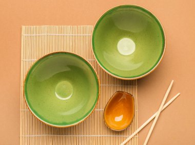 Çin kâseli bambu hasırı ve yemek çubuklarıyla renklendirilmiş arka plan