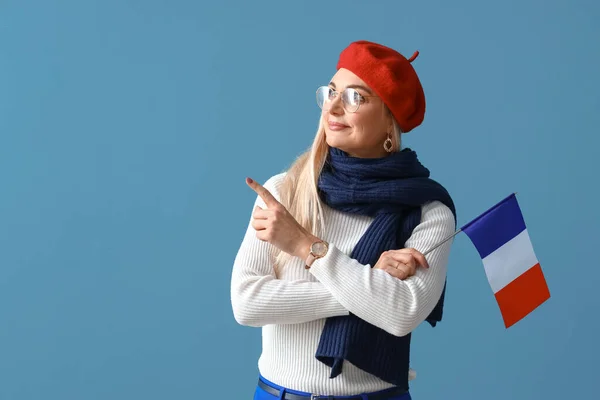 フランスの国旗が青い背景に何かを指している美しい女性 — ストック写真