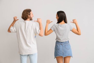 Şık tişörtlü, arka planda genç bir çift.