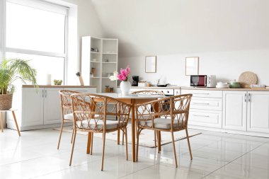 Yemek masası ve sümbül çiçekleri olan şık bir mutfak.