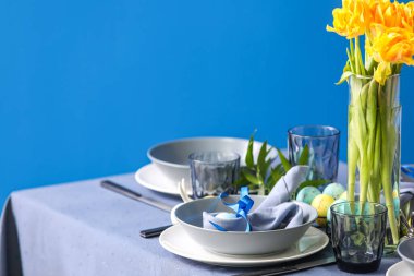 Mavi duvarın yanındaki Paskalya kutlaması için masa servis edildi.